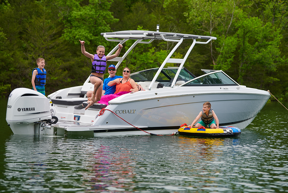 A family playing safely on a Cobalt boat with life jackets